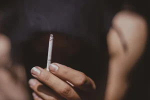 A person considers quitting smoking, at the heart of the debate between two public health goals.